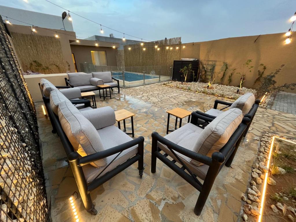 利雅德شاليهات حائط حجري的一个带躺椅的庭院和一个游泳池