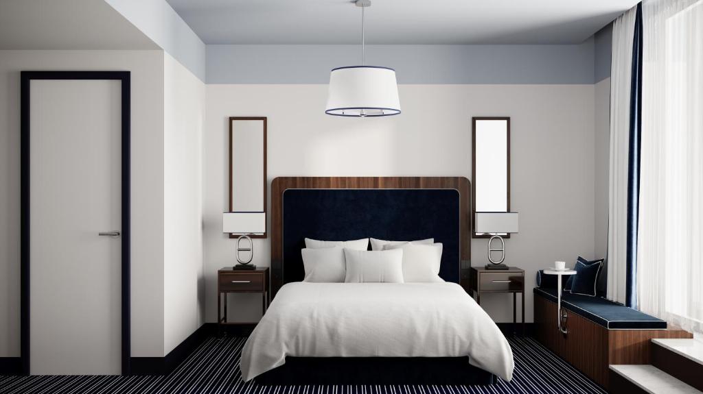 滕斯贝格Hotel Klubben的一间卧室配有一张床、两张桌子和两盏灯。