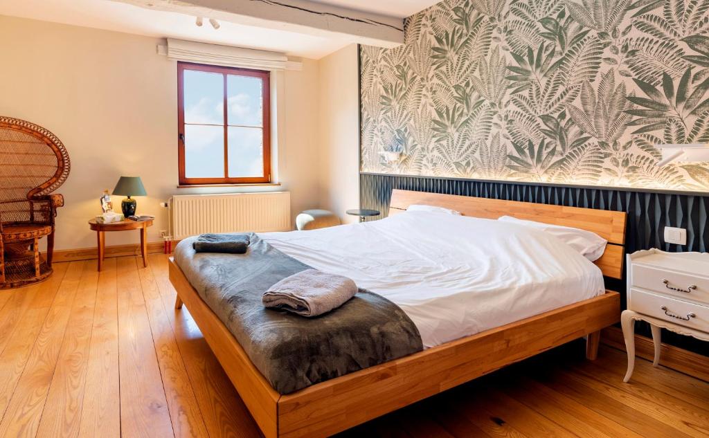 绍德方丹Côté cour, côté source chambre d'hôtes的一间卧室设有一张大床,铺有木地板