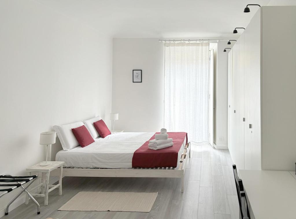 都灵Casa di Carlo, con Poli, metro, caffè a due passi的白色卧室配有红色枕头的床