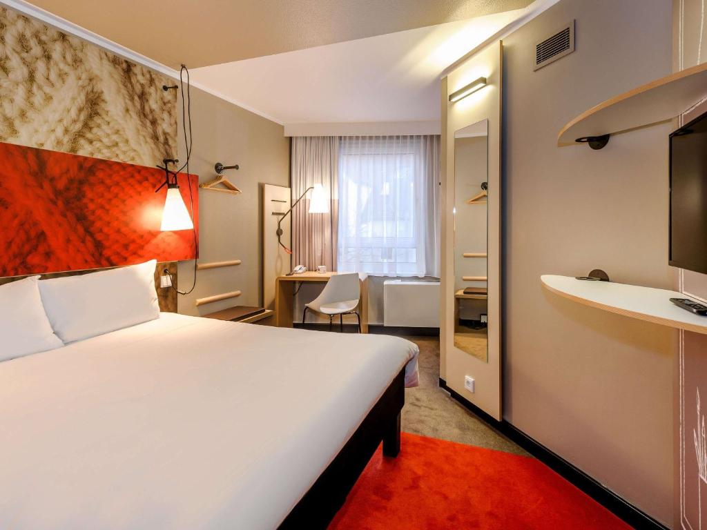 慕尼黑慕尼黑宜必思酒店的酒店客房设有一张大床和一张书桌。