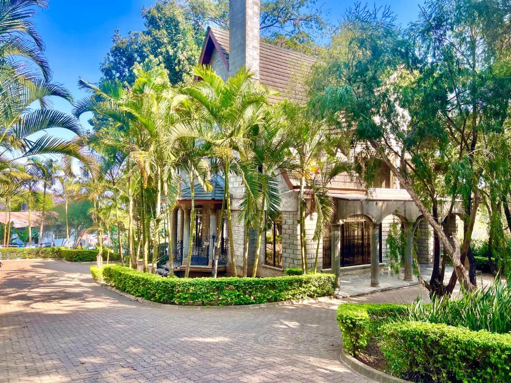 阿鲁沙Wenzi Luxury Home的前面有棕榈树的房子