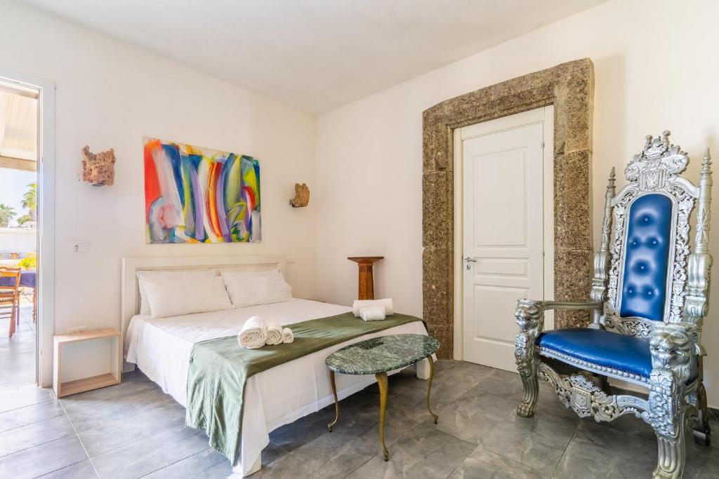 加利波利Masseria Le Dimore的一间卧室配有一张床和一张蓝色椅子