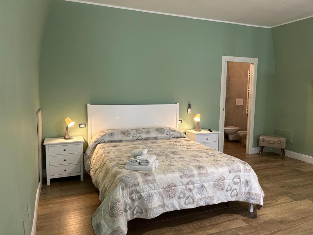 卡诺萨迪普利亚RoMa Apartment & Room的一间卧室设有一张大床和两个床头柜