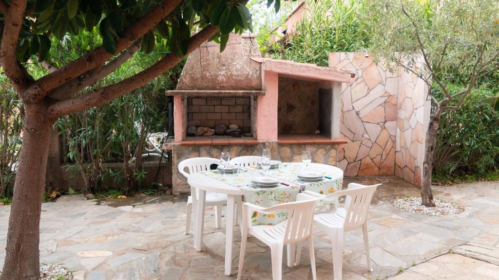 波尔托奥蒂罗卢Casa Ficus的白色的桌子和椅子,砖炉
