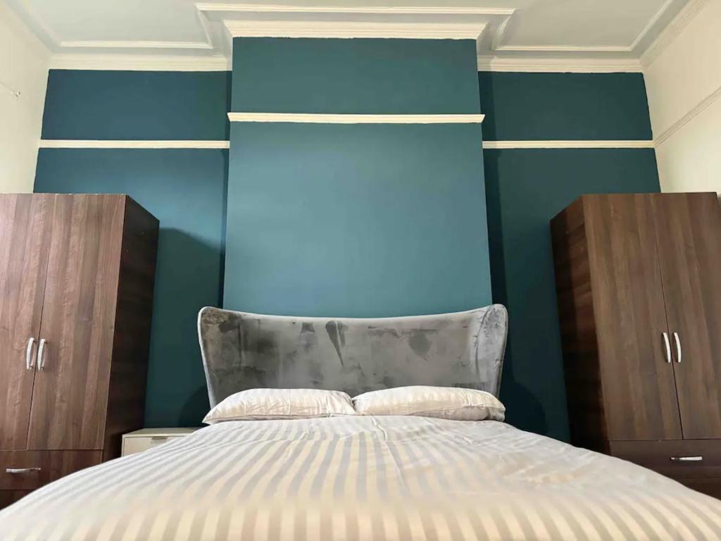 NeepsendComfortable Room in Shared Sheffield Detached House - Room 3的一间卧室设有一张床和蓝色的墙壁