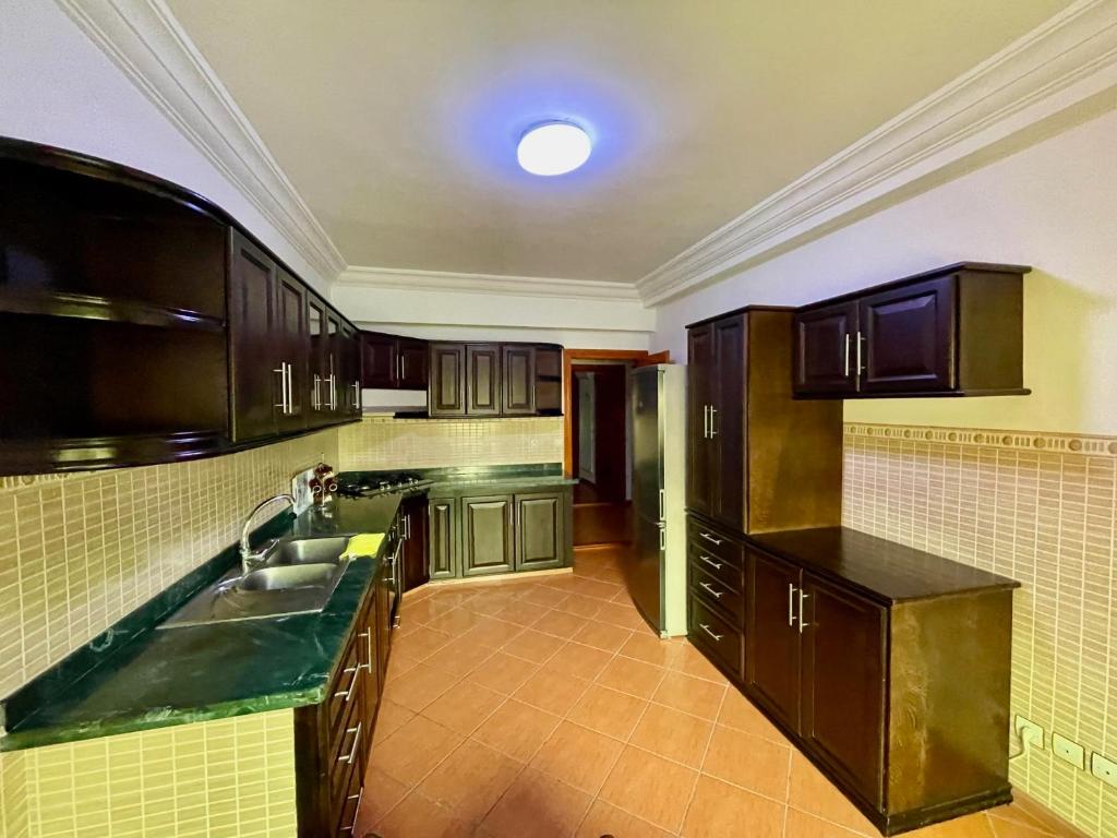 米迪克Sary's Hotel的一个带木制橱柜和水槽的厨房