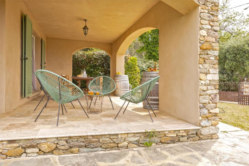 帕特里莫尼奥Casa U Castagnettu的庭院配有两把椅子和一张桌子