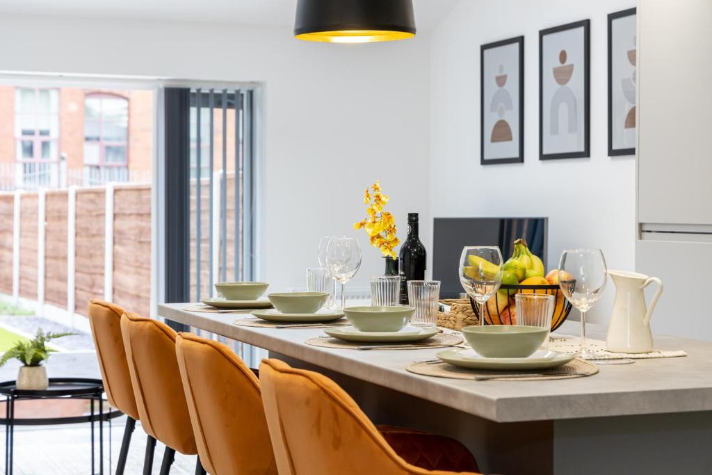 曼彻斯特Spacious & Modern 4-Bedroom Townhouse的用餐室配有桌椅和酒杯