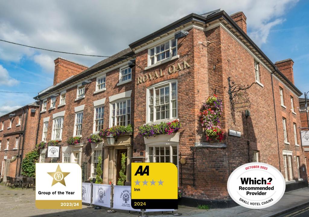 威尔斯浦The Royal Oak Hotel, Welshpool, Mid Wales的前面有黄色标志的砖砌建筑