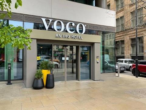 曼彻斯特voco Manchester - City Centre, an IHG Hotel的建筑一侧的时尚商店