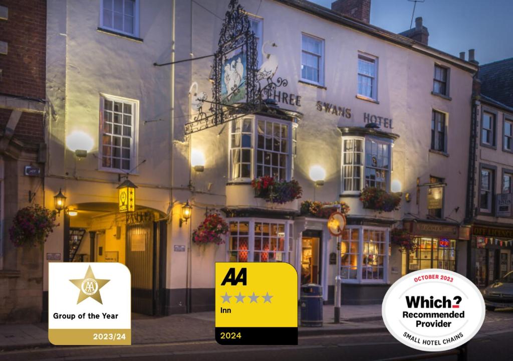 哈波罗集市The Three Swans Hotel, Market Harborough, Leicestershire的前面有标志的酒店