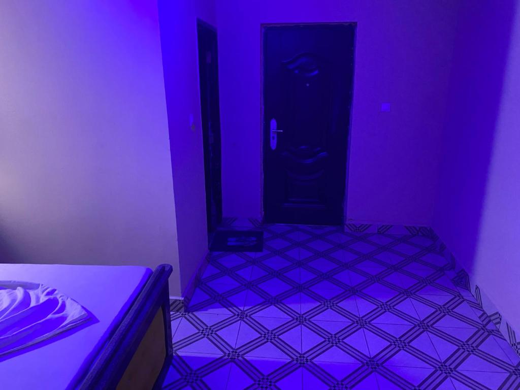 GarouaHouse Of Lottie的一间紫色客房,配有一张床和一扇门