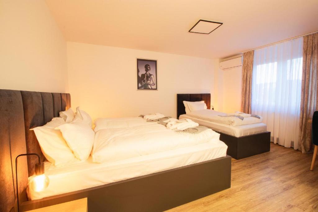 贝尔吉施格拉德巴赫Hotel Dona的配有白色床单的客房内的两张床