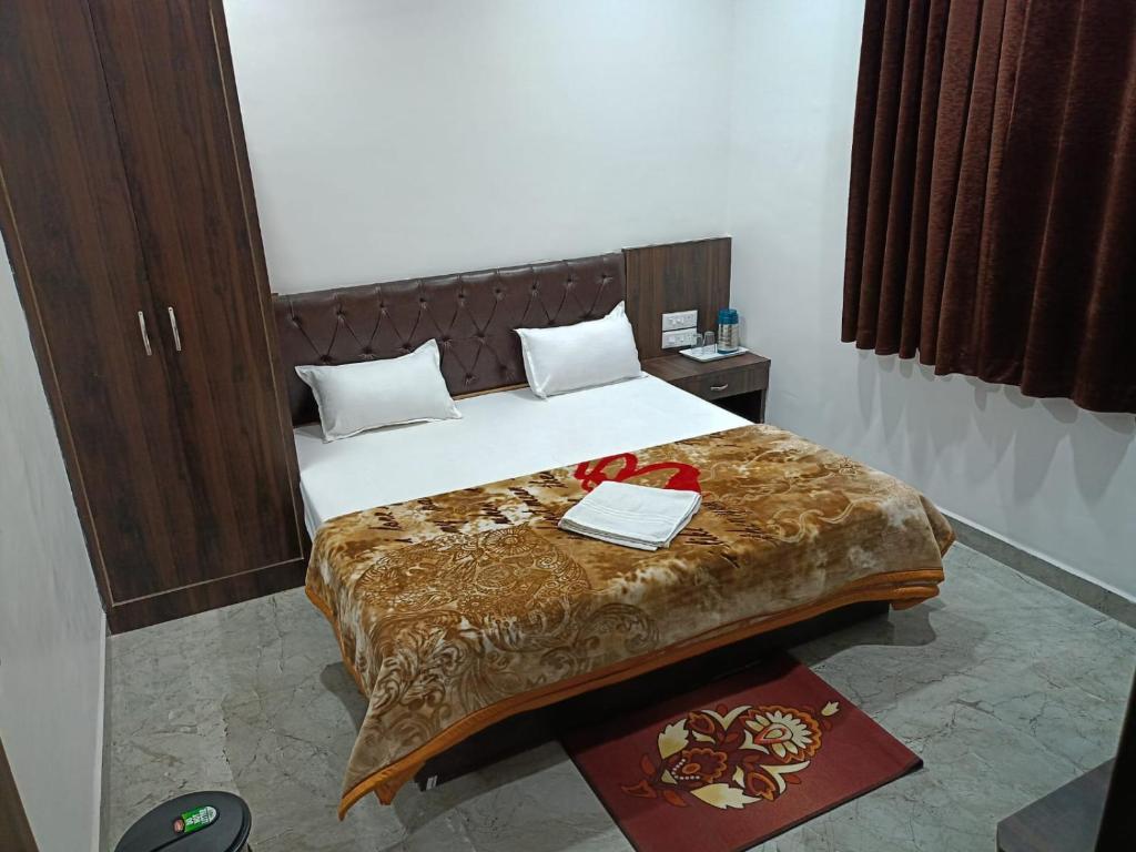 Sītāpur MūāfiHotel Sphatik的一间卧室配有一张大床和木制床头板
