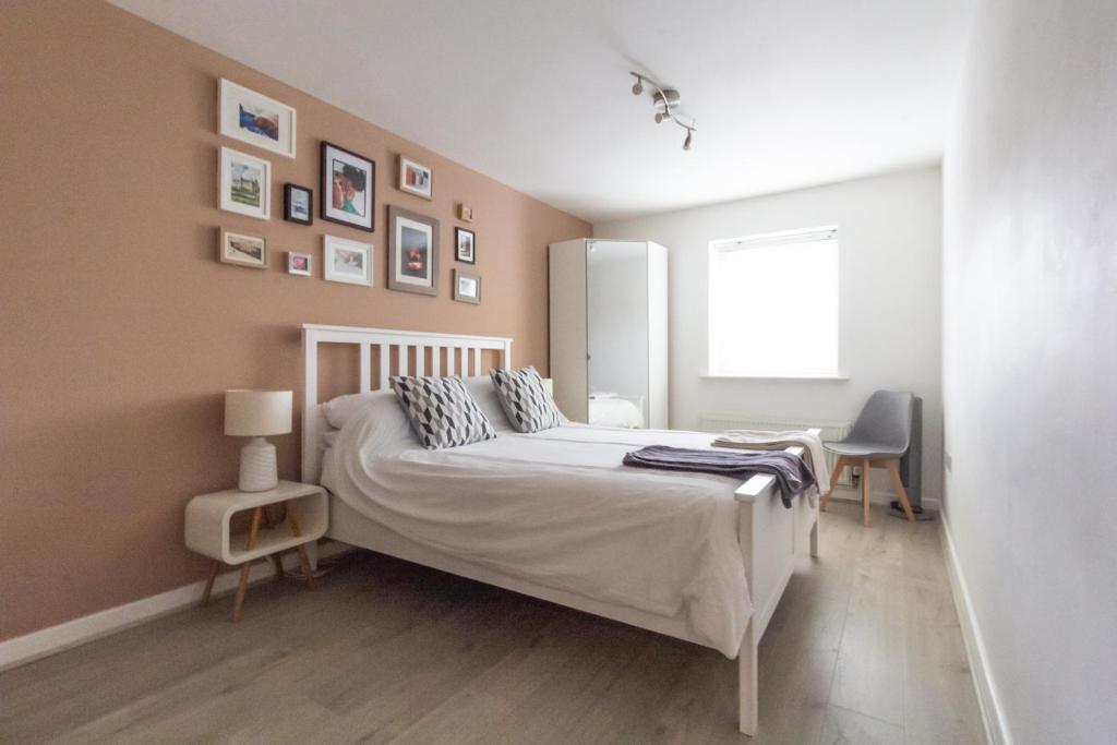 伦敦宽敞中央家庭公寓的卧室配有白色的床和窗户。