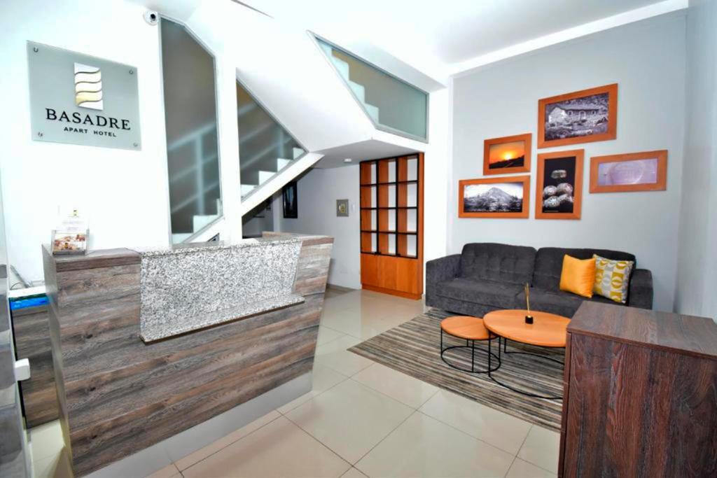 塔克纳Basadre Apart Hotel的客厅配有沙发和桌子