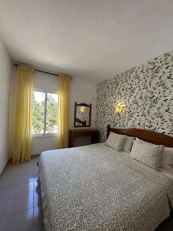阿德耶Costa Azul Apartamento的一间卧室设有一张大床和一个窗户。