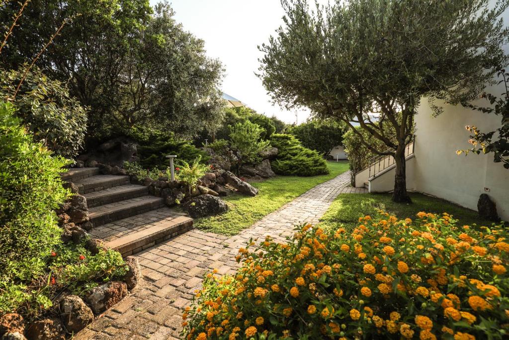 卡斯特尔萨多Il Borgo BagaBaga - Exclusive Country Retreat的一座带石头小径和鲜花的花园