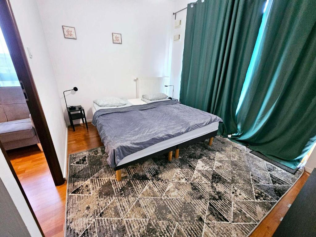 华沙FIRST -- Green Żoliborz apartment 3的一间卧室配有一张带绿帘的床