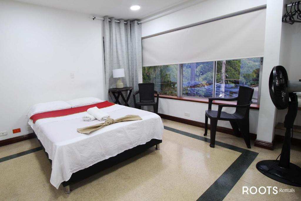 麦德林Apartamento privado en Medellin MAG301的一间卧室配有一张床、一张书桌和一个窗户。