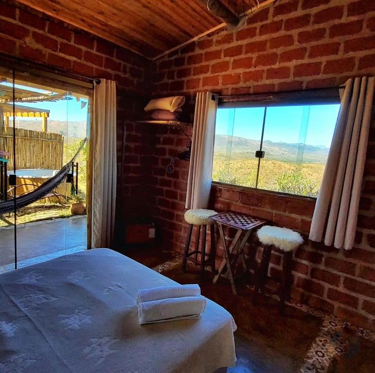 西波山Rancho da Montanha Cipó的一间卧室设有一张床和一个美景窗户。