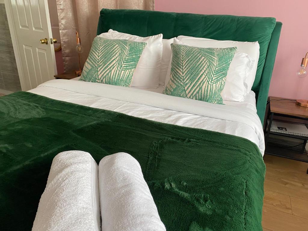 Corfe MullenThe Lily Pad的一张配有绿色床单和枕头的大床