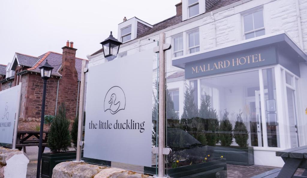 吉伦The Mallard Hotel的白色建筑窗户上的标志