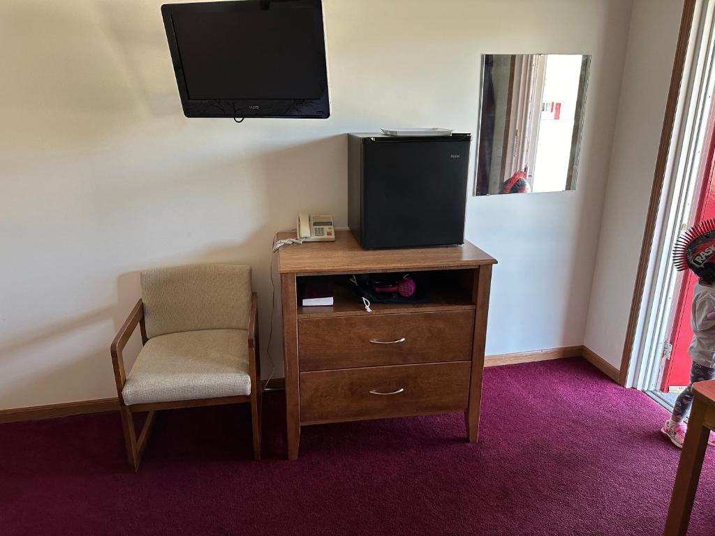 拉丁顿VISTA VILLA MOTEL的客房设有一张桌子、一台电视和一把椅子