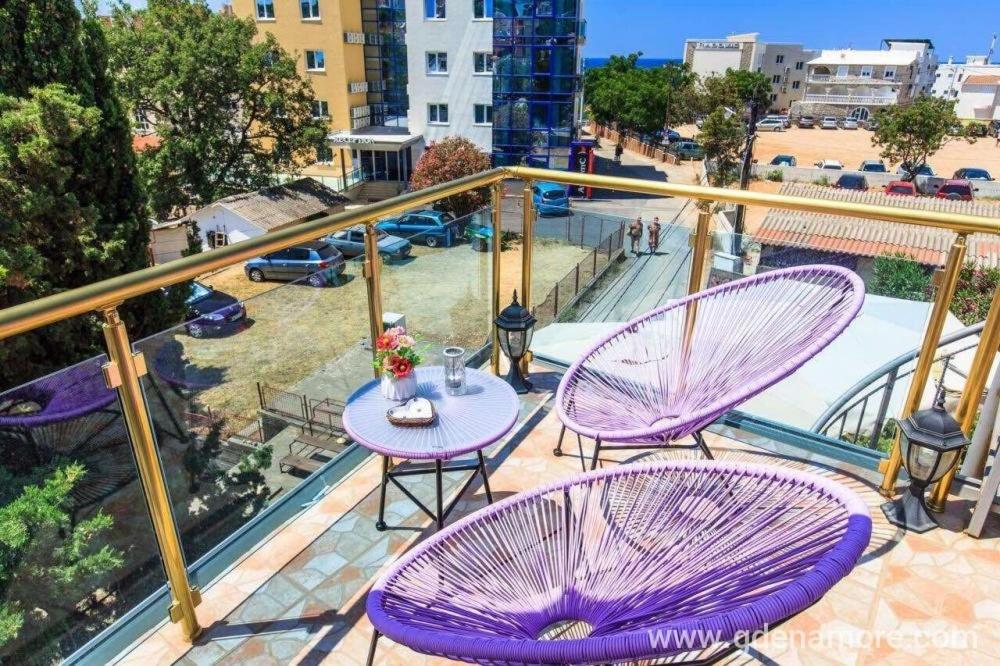 布德瓦Hotel Amon的阳台配有2把紫色椅子和1张桌子