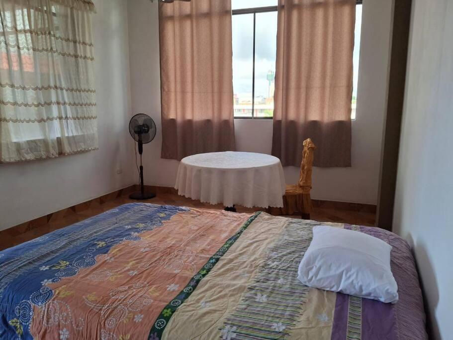 马尔多纳多港Disfruta la Selva Peruana Pto.M的一间卧室,配有一张床和一张桌子,位于窗户上
