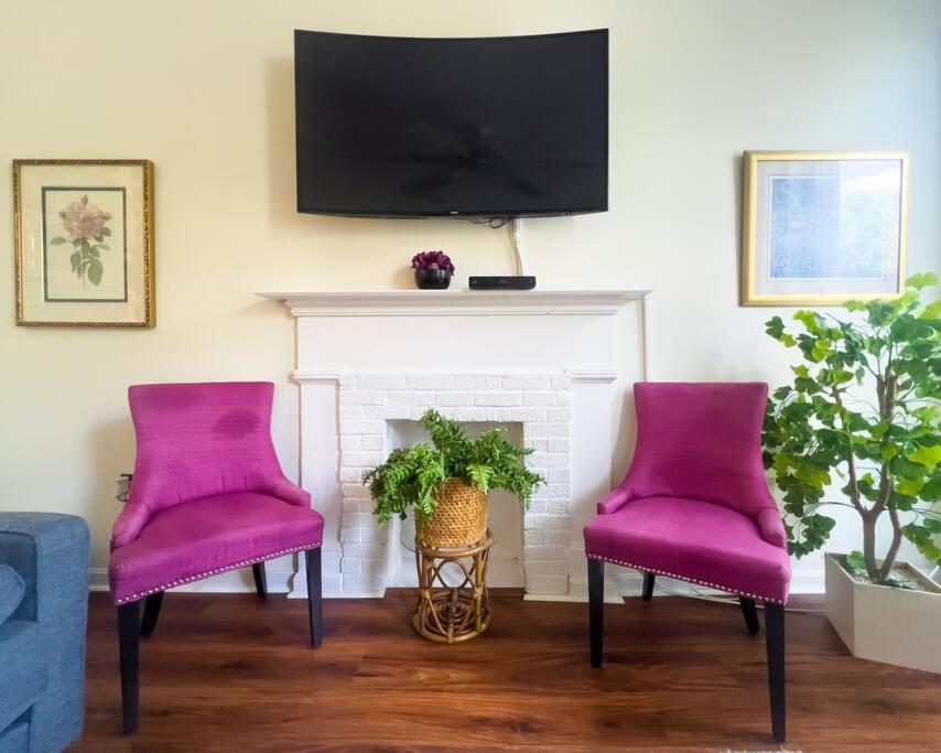 路易斯威尔Mon Fournissuer 4bd Home with backyard的带壁炉的客厅配有两把紫色椅子