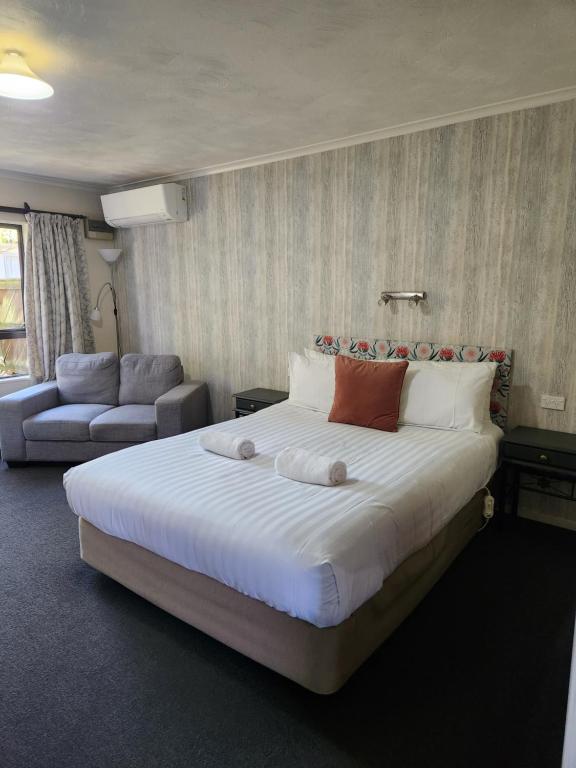 纳尔逊Amber Court Motel Nelson的一间卧室配有一张大床和一张沙发