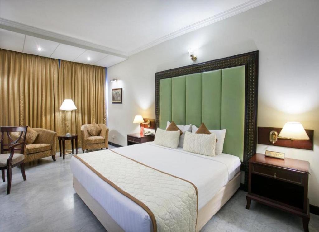 新德里Hotel ALVAA GRAND Near Delhi Airport BY-AERO HOME STAY的酒店客房设有一张大床和绿色床头板