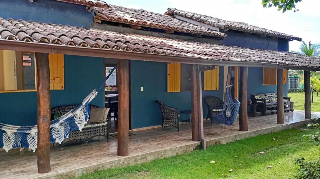 巴拉格兰德Chalé em Maraú pertinho da praia的蓝色房子,甲板上设有吊床