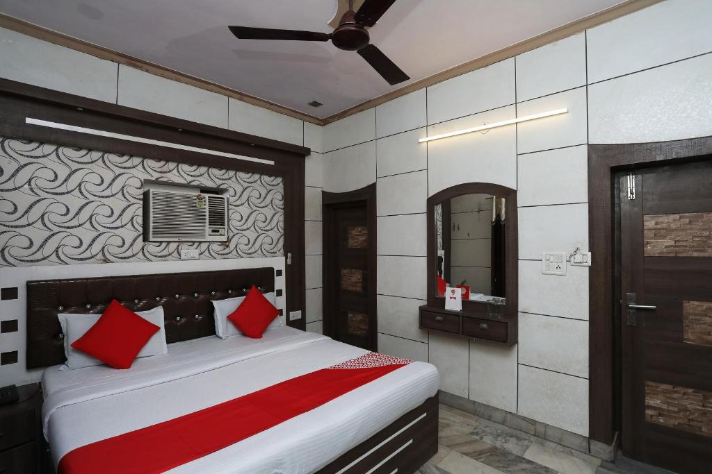 阿格拉OYO Hotel Vanshika的一间卧室配有一张带红色枕头和镜子的床
