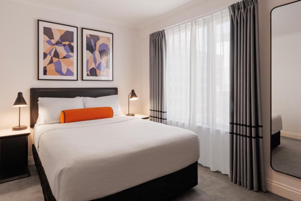 奥克兰奥克兰城市生活酒店的一间卧室设有一张床和一个大窗户