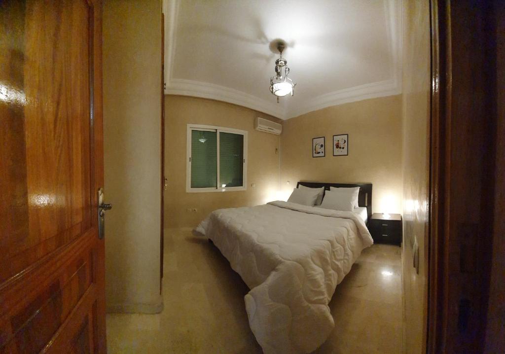 马拉喀什Cozy apartment in the heart of marrakech的一间卧室设有床、窗户和门