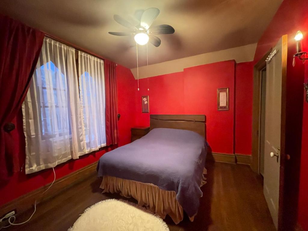 尼亚加拉瀑布THE RED STAR ROOM A的红色卧室设有一张床和一个吊扇