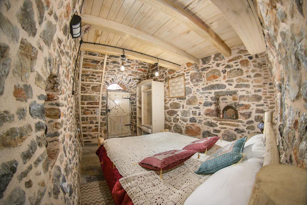 梅斯塔Byzantine Home in the Castle的卧室配有一张石墙床