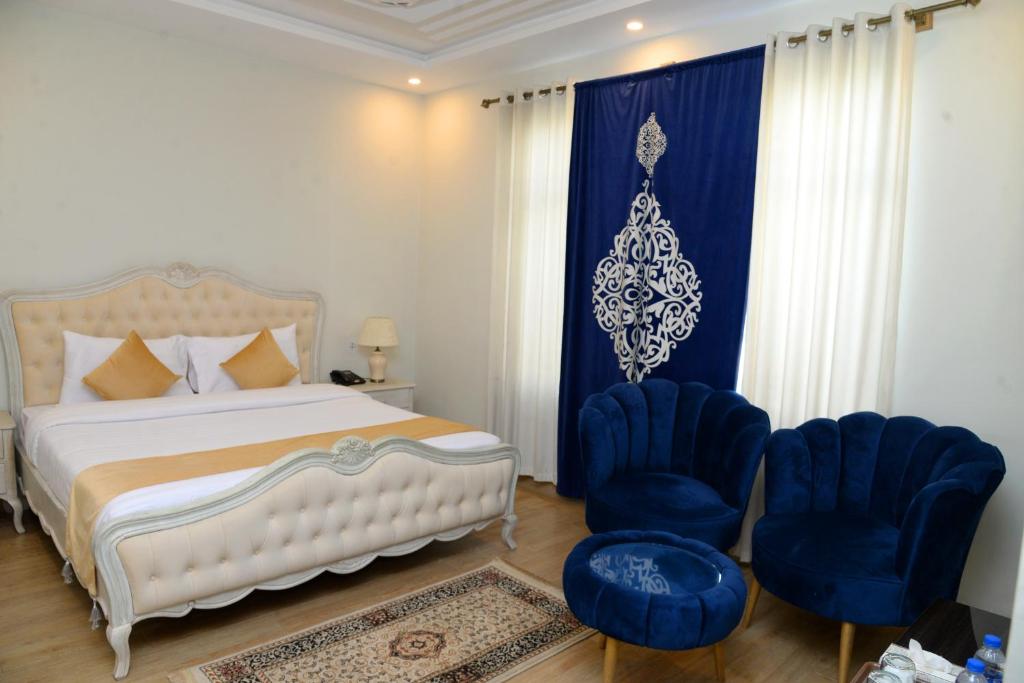 锡卡都Kallisto Resort Skardu的一间卧室配有一张床和两张蓝色椅子