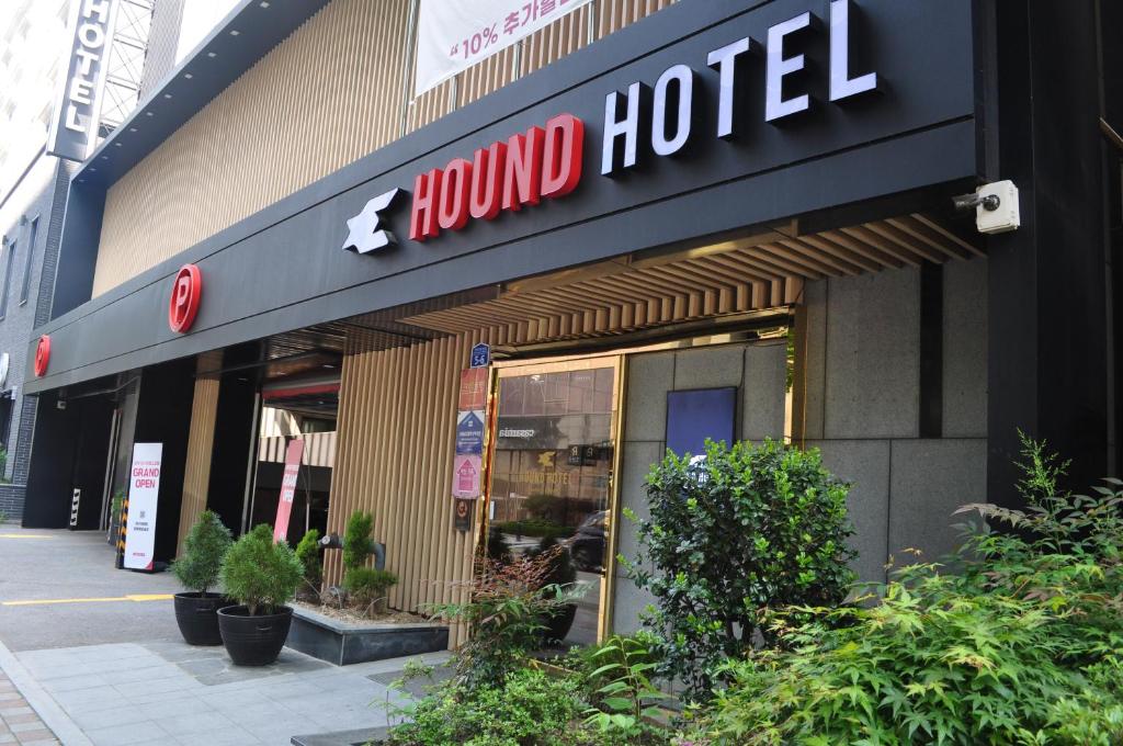 光州HOUND Hotel Sangmu的大楼前的受伤酒店标志