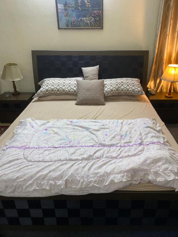 罕萨Home of golden oriole的一张配有白色床单和枕头的大床