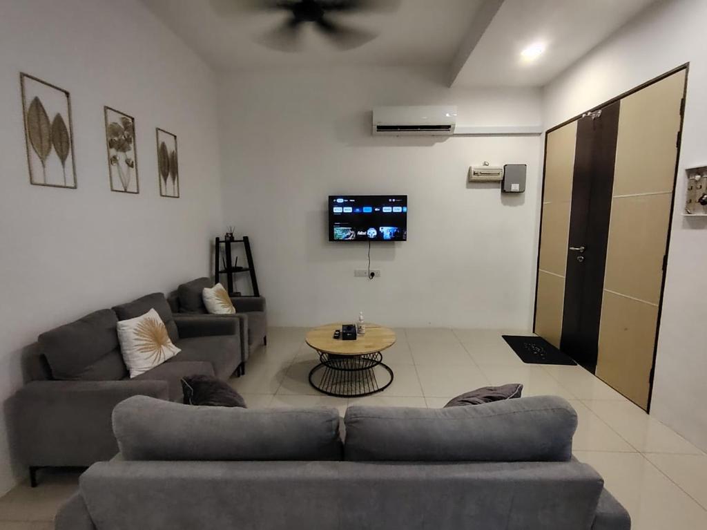 米里Miri Serene Shangrila, Luak with 4-bedroom的客厅配有两张沙发和一张桌子