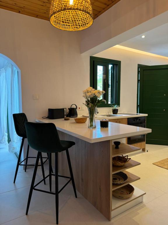利马索尔Pirella House的一个带两把椅子和台面的大岛的厨房