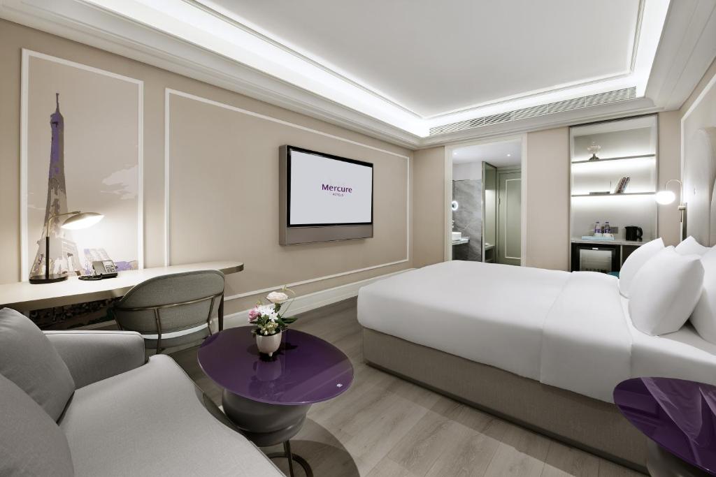深圳深圳南山深圳湾美居酒店的一间带特大号床的卧室和一间客厅