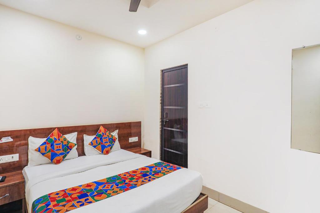 赖布尔FabExpress Convivial Star的一间卧室配有带色彩缤纷枕头的床