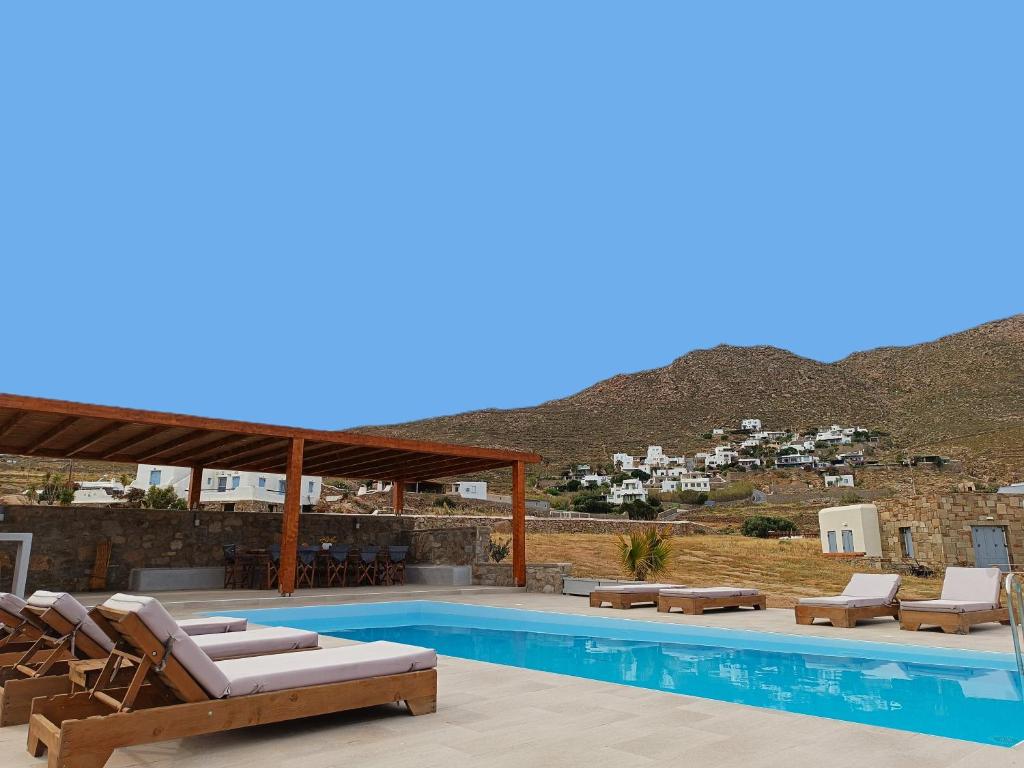 图罗斯Megusta Mykonos的一个带躺椅的游泳池和一个山