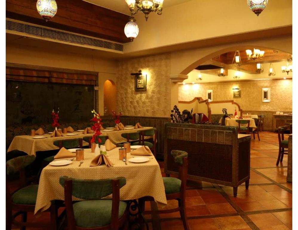 RaigarhHotel Ans International, Raigarh,的一间在房间内配有桌椅的餐厅