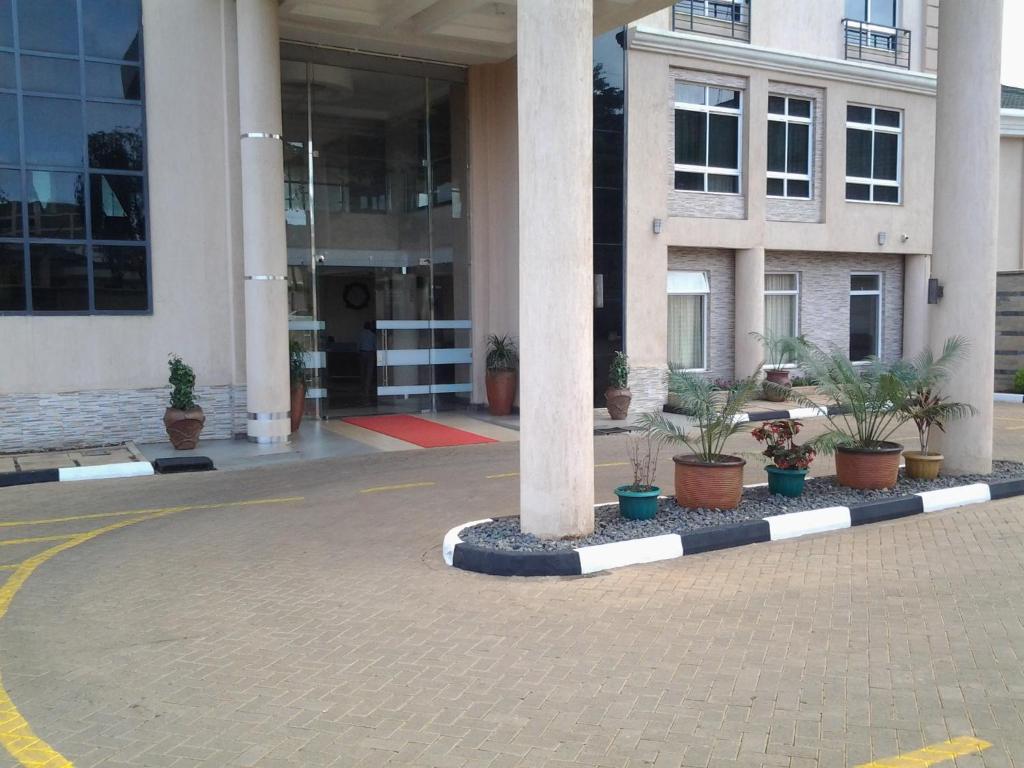 MeruThree Steers Hotel的前面有柱子和盆栽植物的建筑